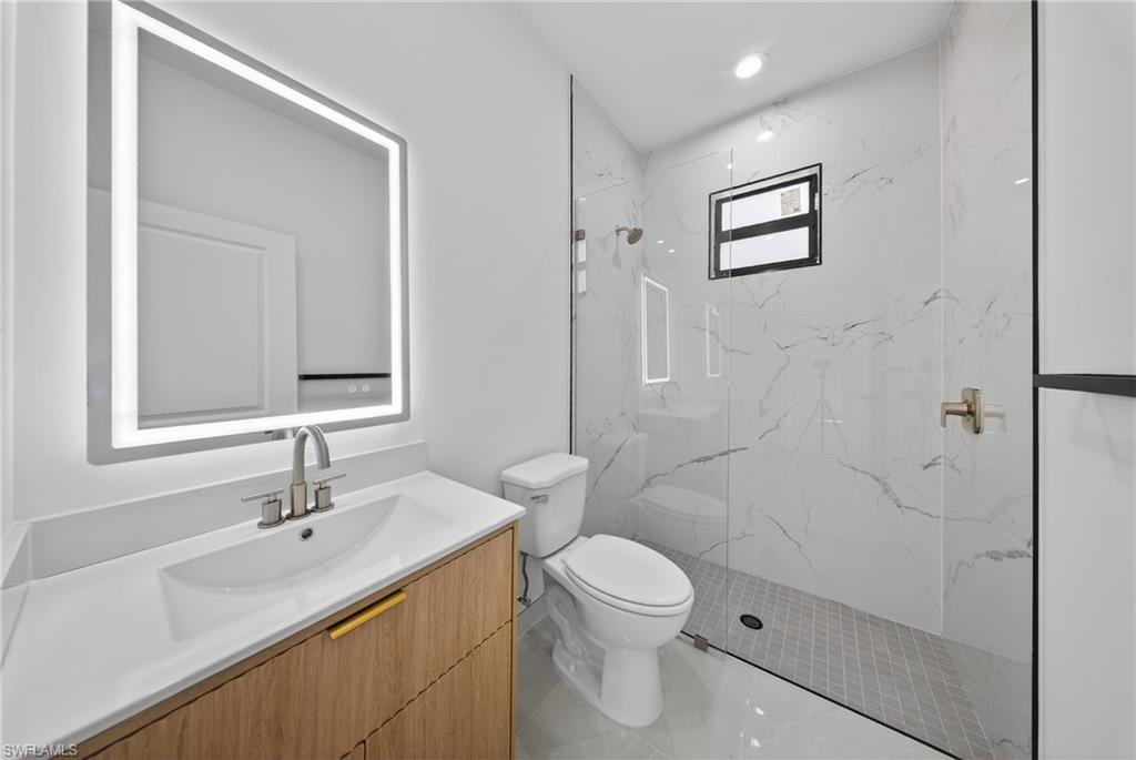 Full bath with vanity and a marble finish shower
