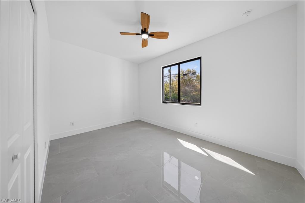 Empty room featuring baseboards and a ceiling fan