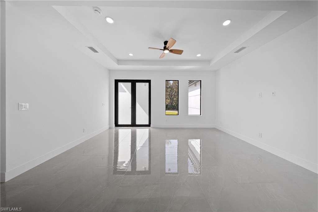Unfurnished room featuring a tray ceiling, ceiling fan, and recessed lighting