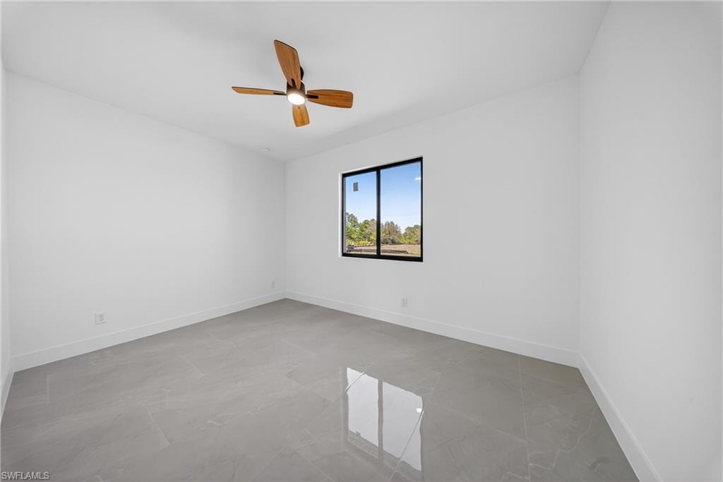 Spare room featuring baseboards and ceiling fan