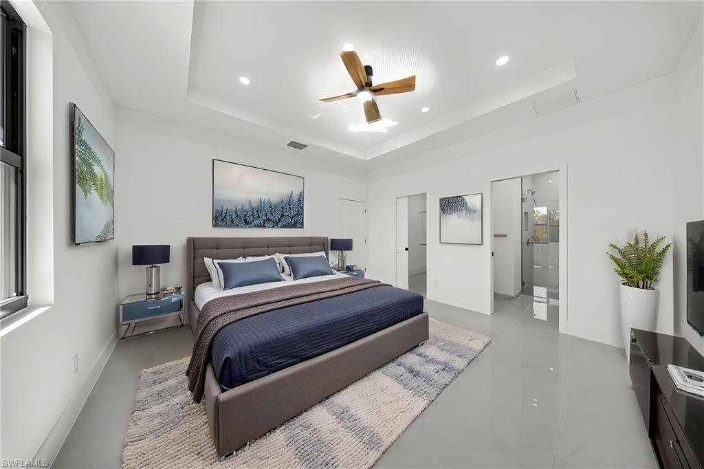Bedroom featuring ceiling fan, recessed lighting, and a tray ceiling