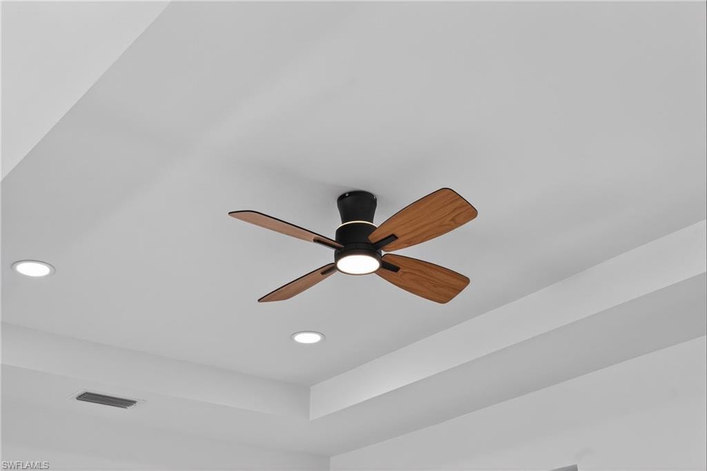 Detailed view of recessed lighting, ceiling fan, and a raised ceiling