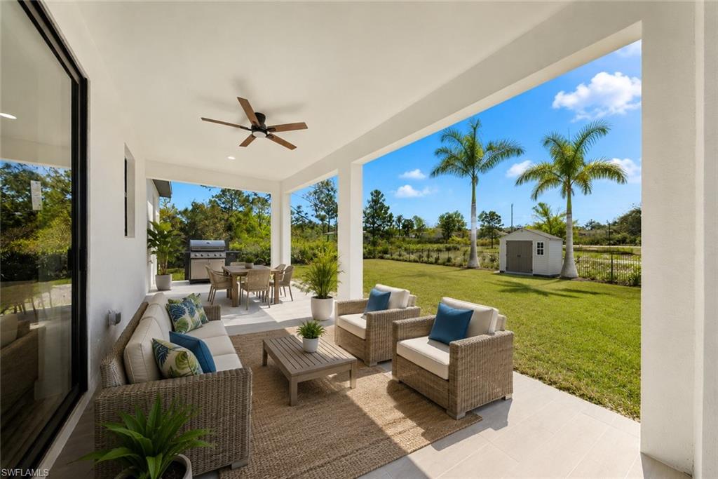 Spacious covered patio featuring a ceiling fan, outdoor dining area, and concrete flooring