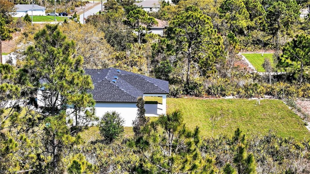 View from above of property with a tree filled landscape