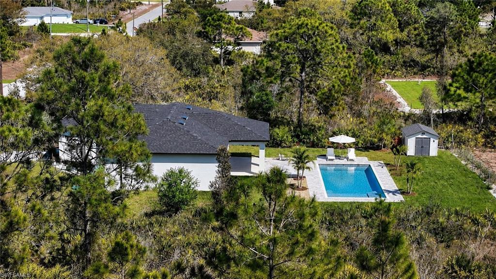 Contemporary residence featuring a dark shingle roof and white exterior