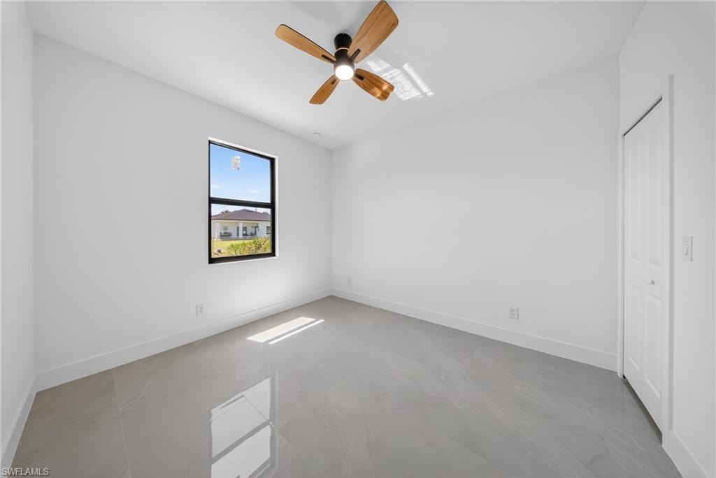 Unfurnished bedroom with ceiling fan and a closet