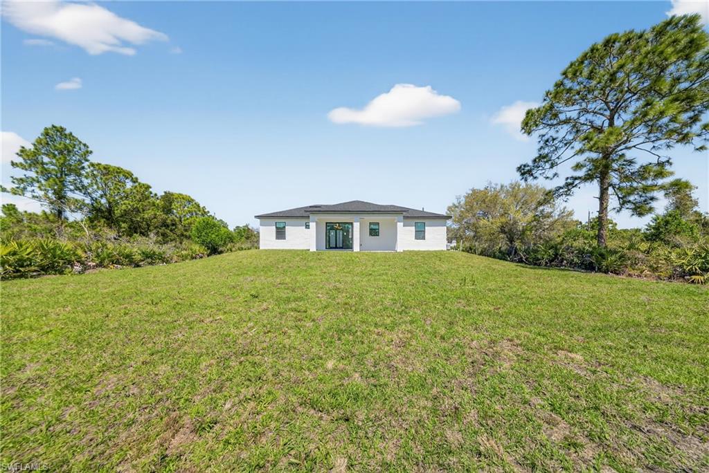 Back of property featuring a lawn