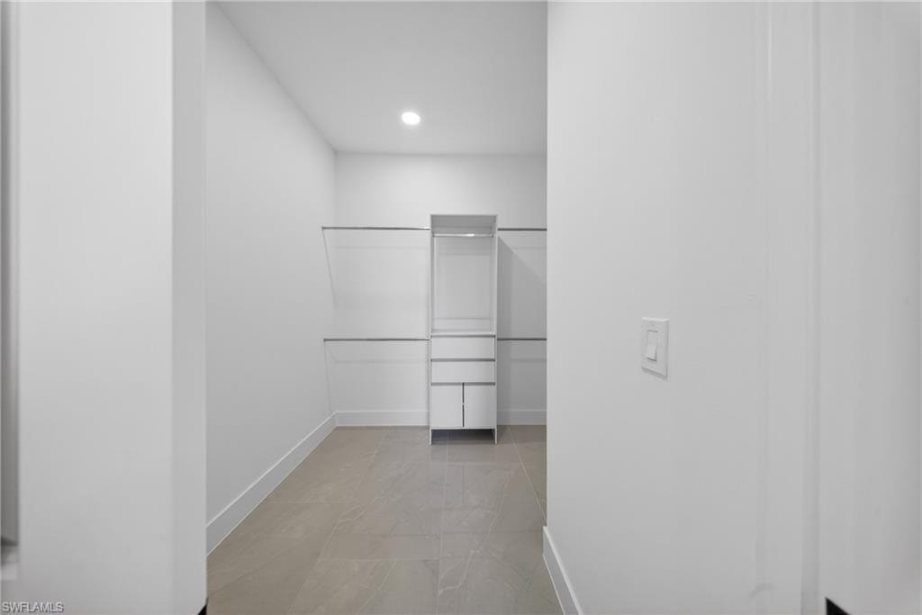 Walk in closet with light marble finish flooring