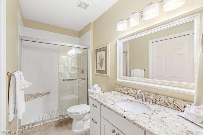 Full bathroom with vanity and a shower stall