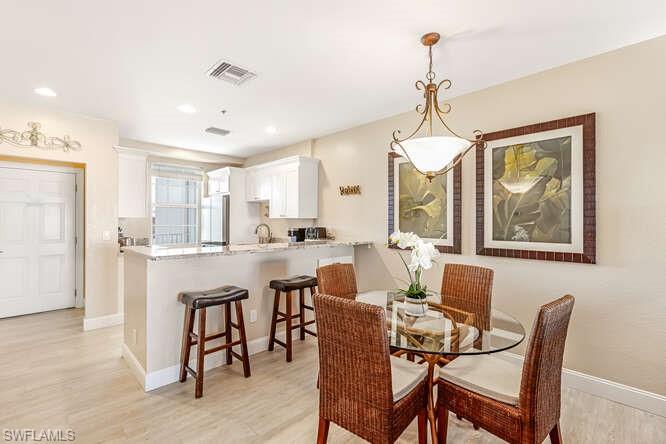 Dining area with light wood-style floors and recessed lighting
