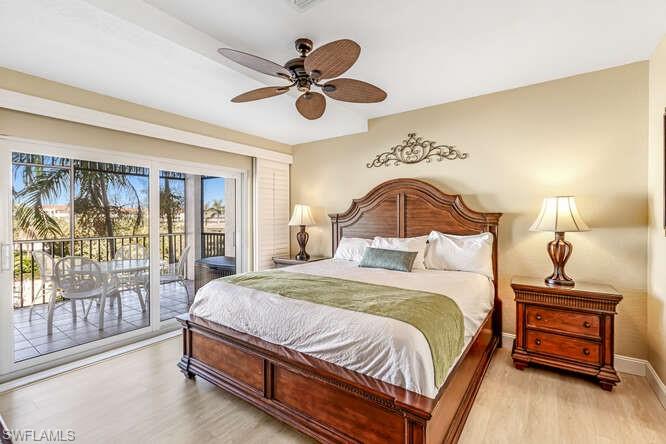 Bedroom with wood finished floors, access to outside, and ceiling fan