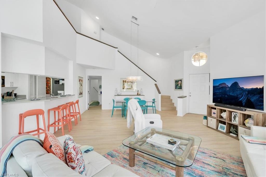 Living room featuring a high ceiling and light wood-type flooring