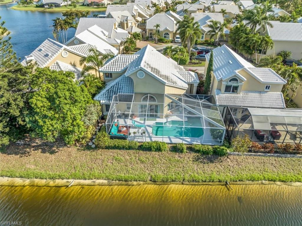 Aerial perspective of suburban area with a nearby body of water and a pool