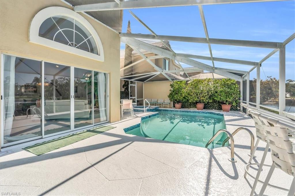 Outdoor pool with a sunroom, a patio area, and a lanai