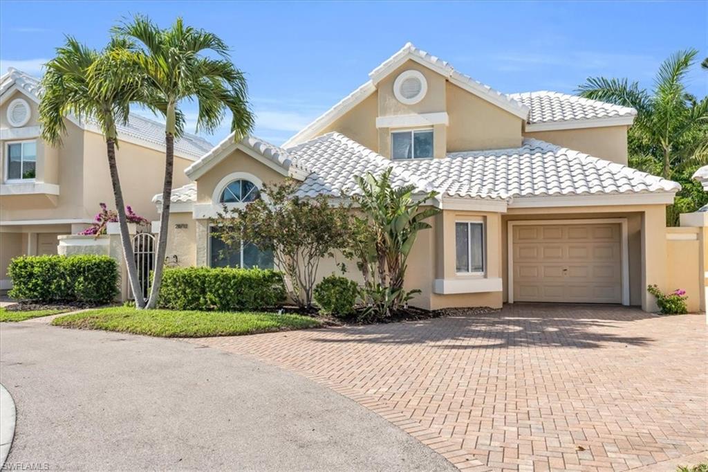 Mediterranean / spanish-style home with a garage, decorative driveway, stucco siding, and a tile roof