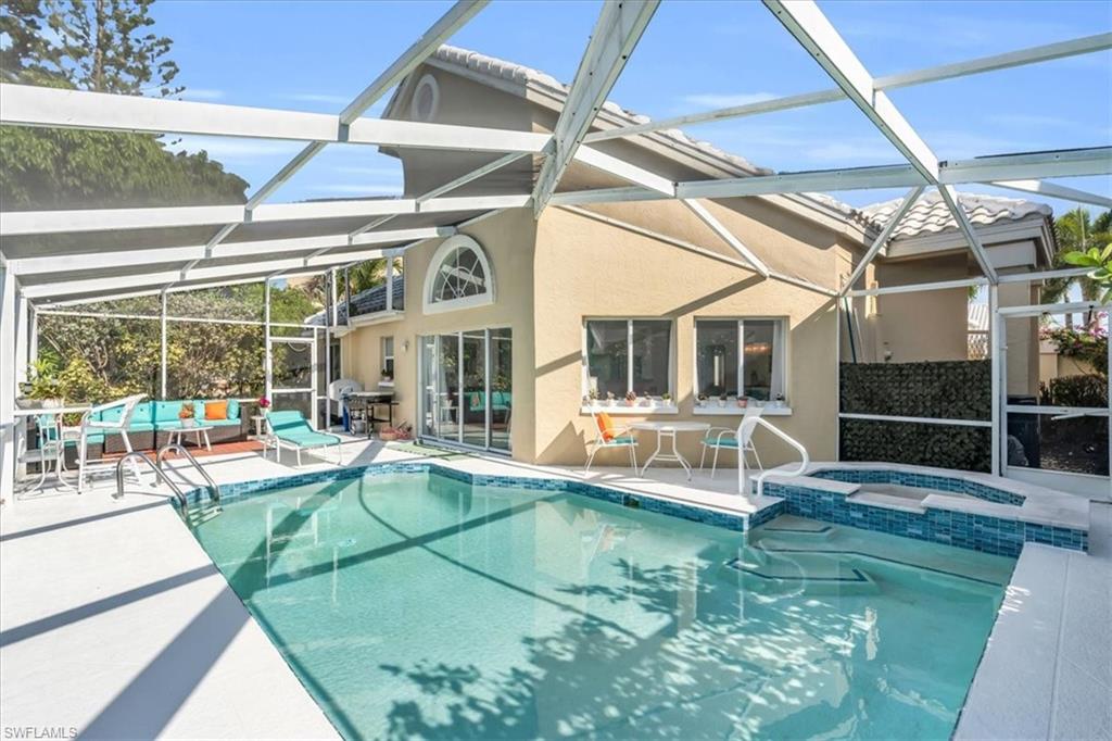 Combined pool / hot tub with a sunroom, a lanai, a patio area, and outdoor lounge area