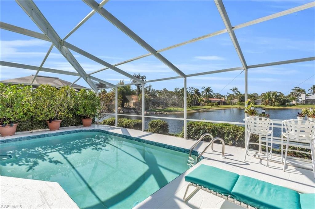 Swimming pool with a sunroom, glass enclosure, and a water view