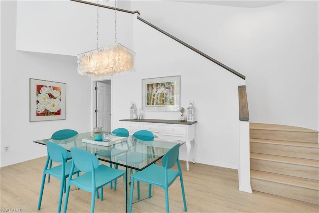 Dining room with light wood-type flooring and a high ceiling
