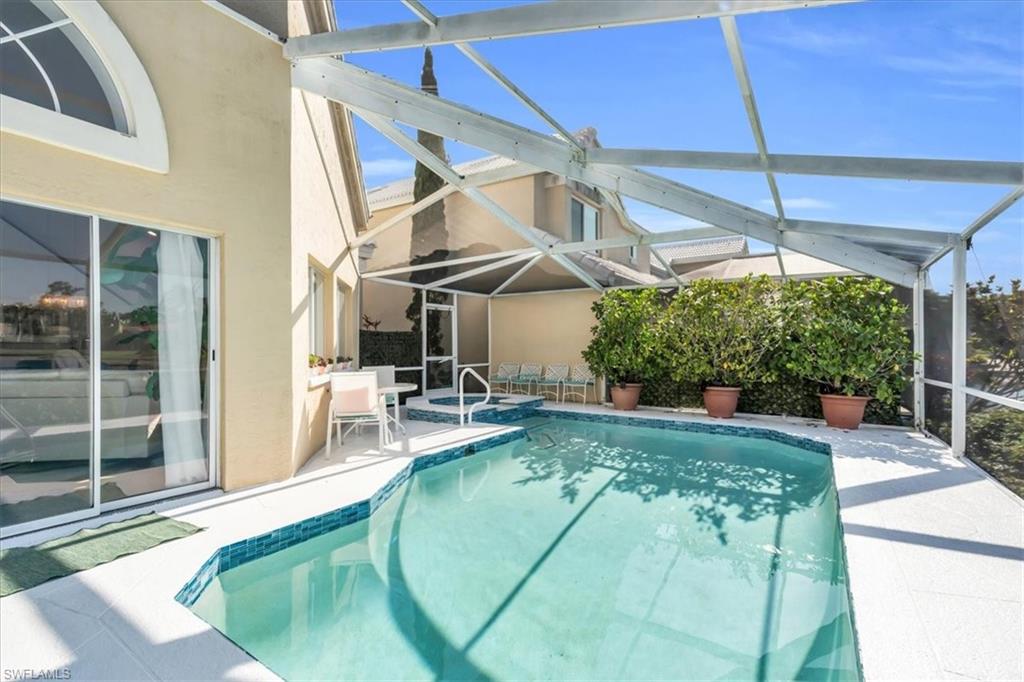 Relaxing pool / spa featuring a sunroom, a patio, and a lanai