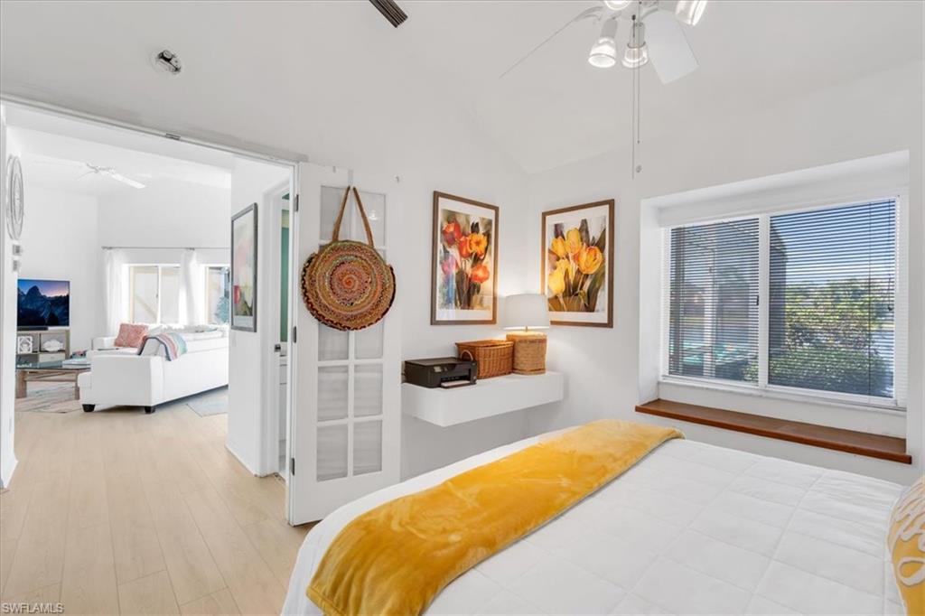 Bedroom featuring light wood-type flooring, a ceiling fan, and lofted ceiling