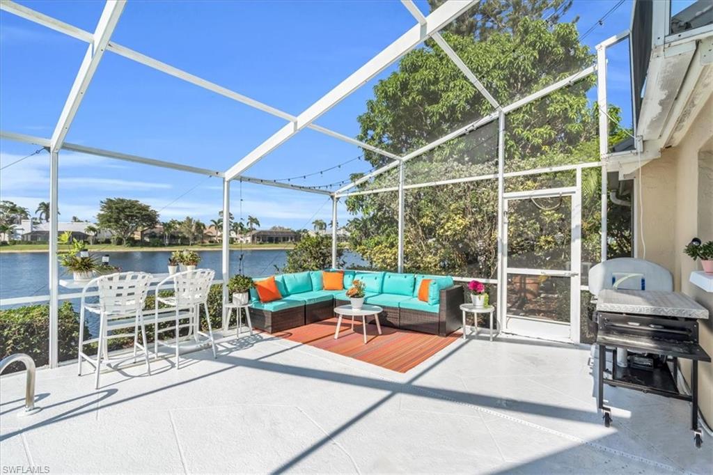 View of patio featuring a sunroom, a lanai, an outdoor hangout area, and a grill