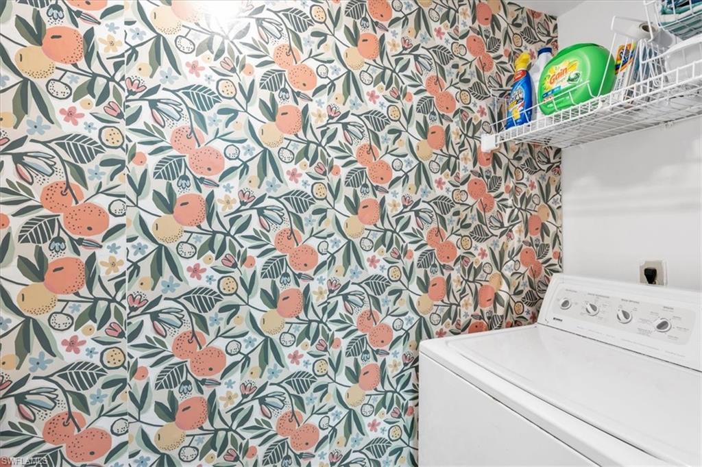 Laundry room with washer / clothes dryer and wallpapered walls