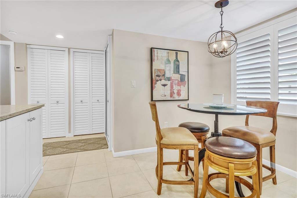 Dining space with light tile patterned flooring and a chandelier