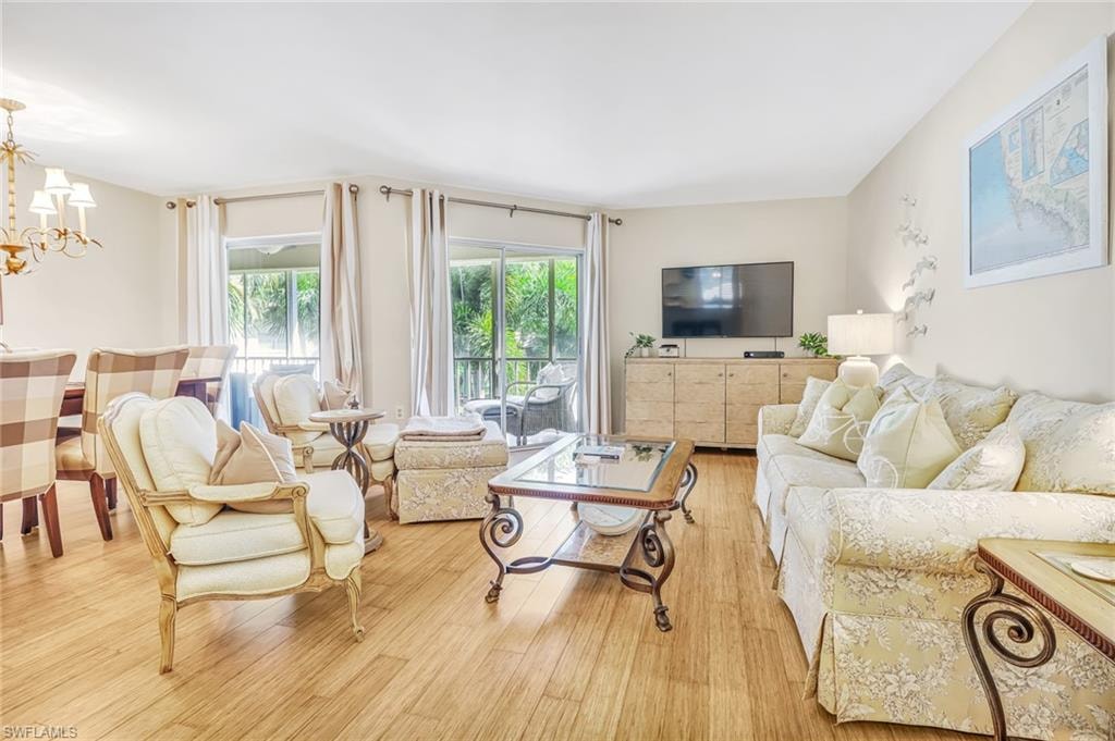 Living area featuring light wood finished floors, plenty of natural light, and hanging lights