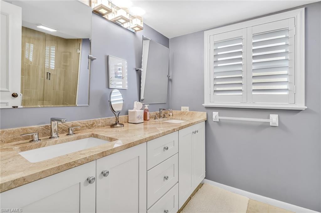 Full bathroom featuring double vanity and baseboards