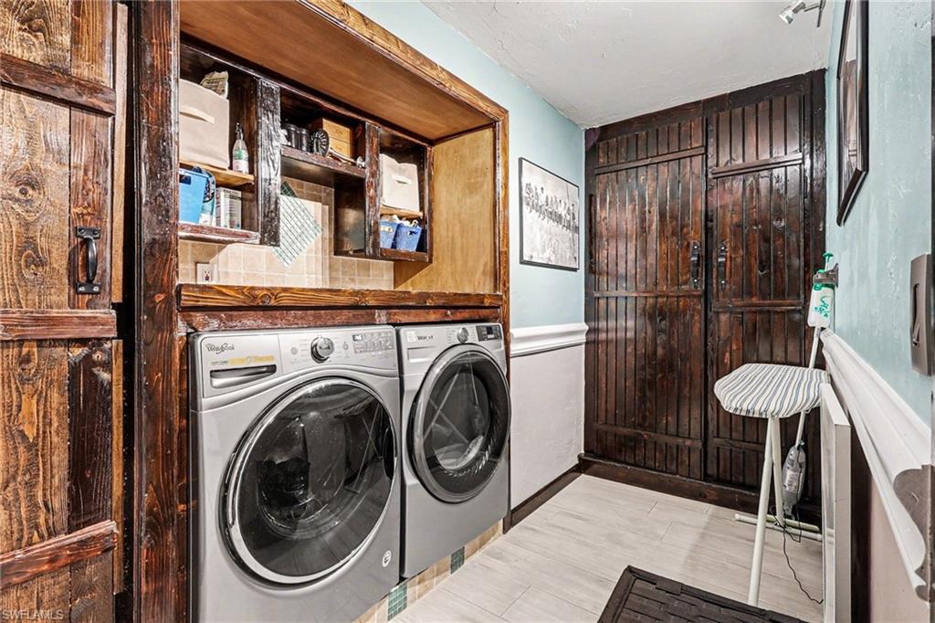 Laundry area featuring washer and dryer and a wainscoted wall