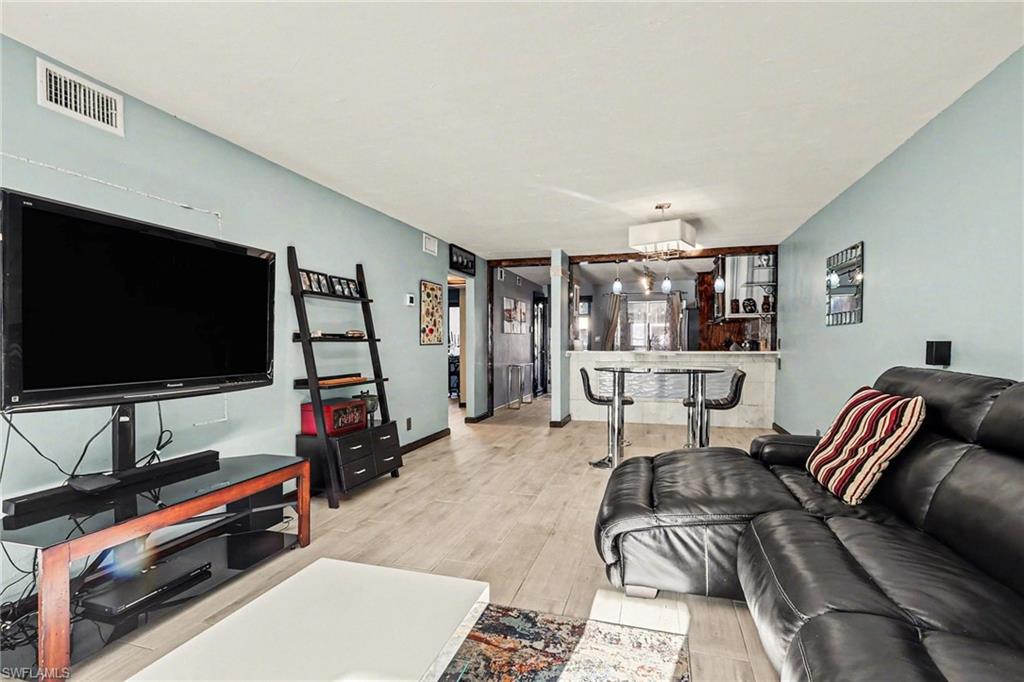 Living area featuring light wood-type flooring and a bar