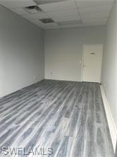 Unfurnished room featuring a paneled ceiling and wood finished floors