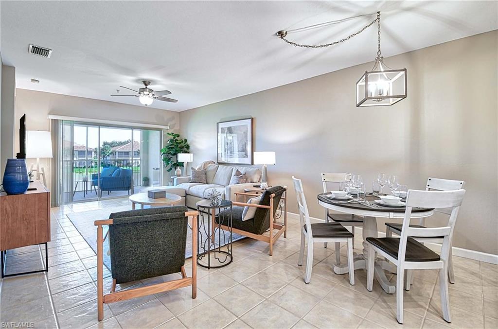 Living room with a ceiling fan and light tile patterned floors