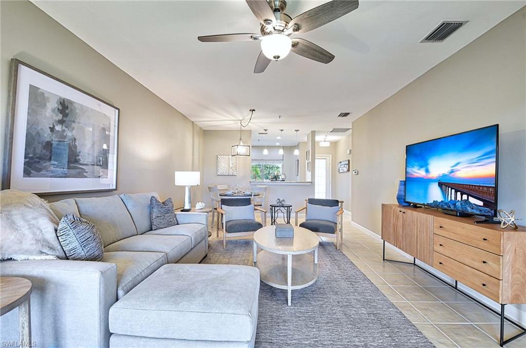 Living area featuring a ceiling fan and light tile patterned floors
