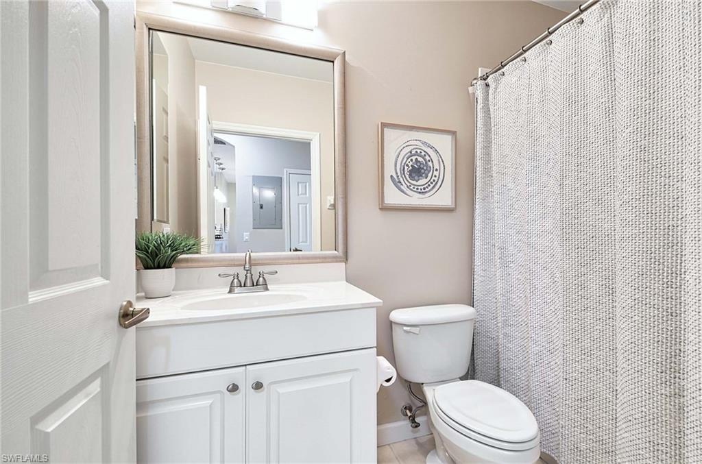 Full bath featuring vanity, a shower with curtain, and electric panel