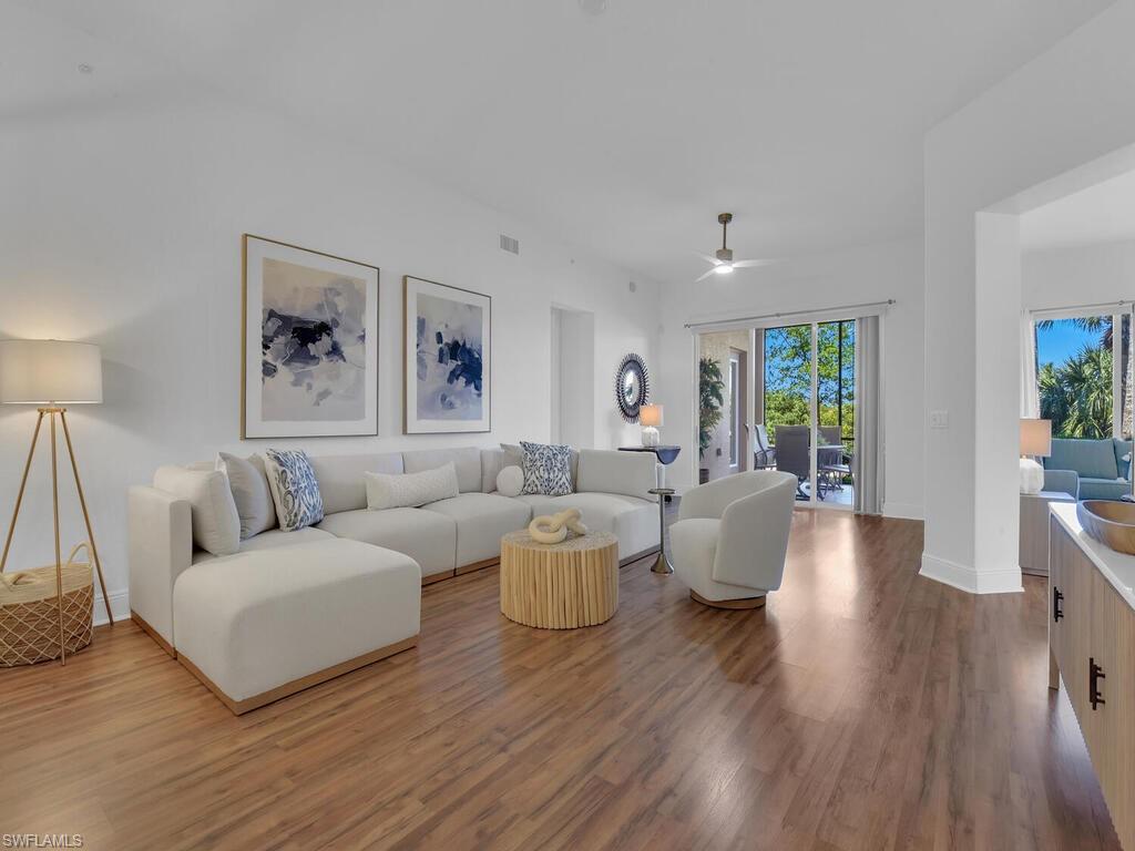 Living area with visible vents, baseboards, ceiling fan, and wood finished floors