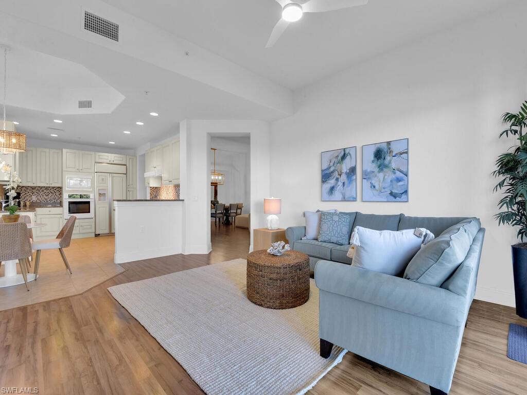 Living area featuring recessed lighting, ceiling fan with notable chandelier, baseboards, visible vents, and light wood-style flooring