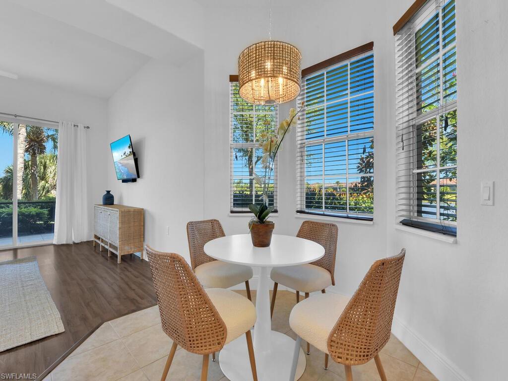 Dining area featuring baseboards, an inviting chandelier, tile patterned floors, and plenty of natural light