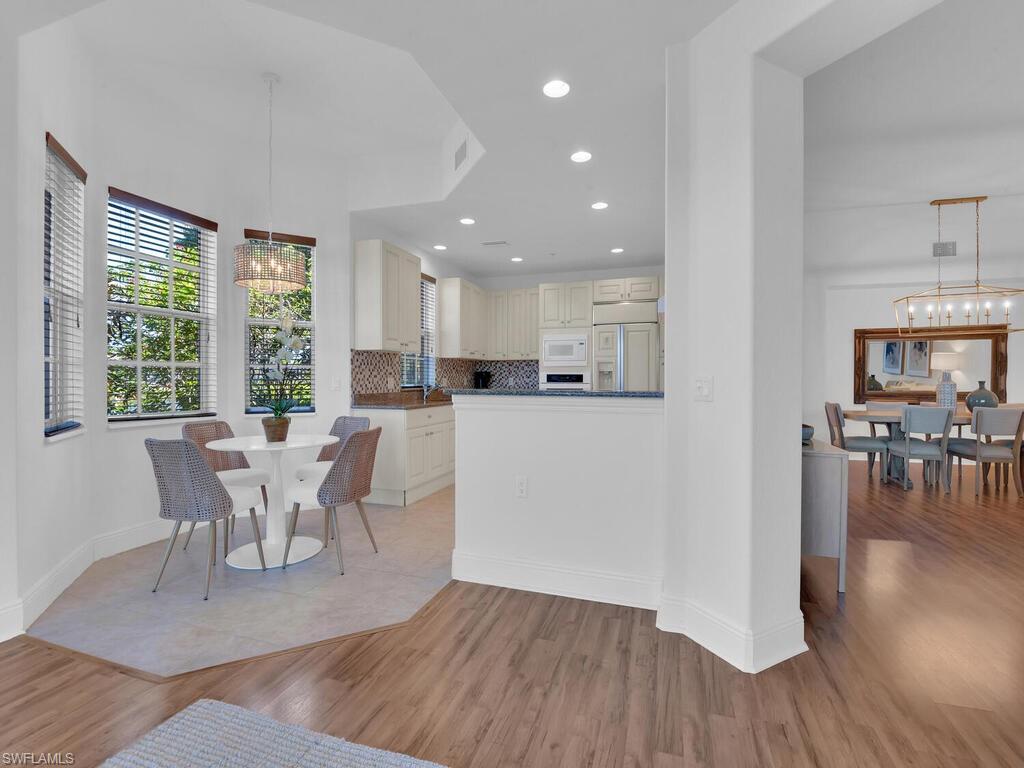 Dining space featuring baseboards, light wood-style floors, recessed lighting, and an inviting chandelier
