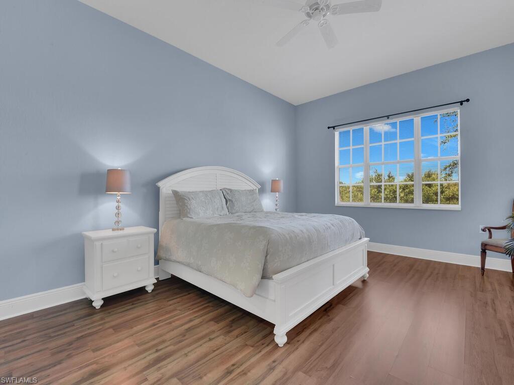 Bedroom with baseboards, wood finished floors, and a ceiling fan