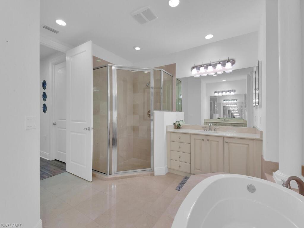 Full bath featuring a shower stall, visible vents, recessed lighting, and vanity