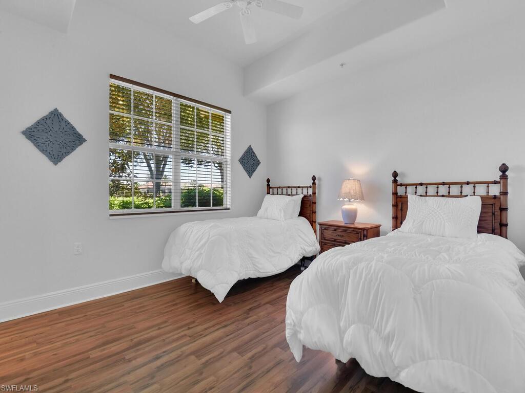 Bedroom featuring baseboards, wood finished floors, and a ceiling fan