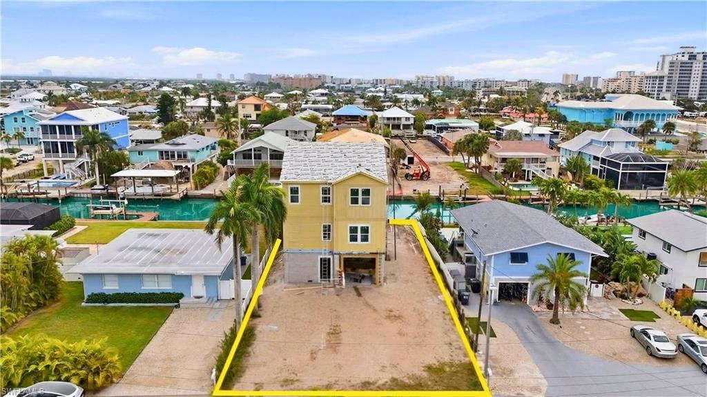 Aerial view of residential area featuring property parcel outlined and a nearby body of water - Virtually Edited Image