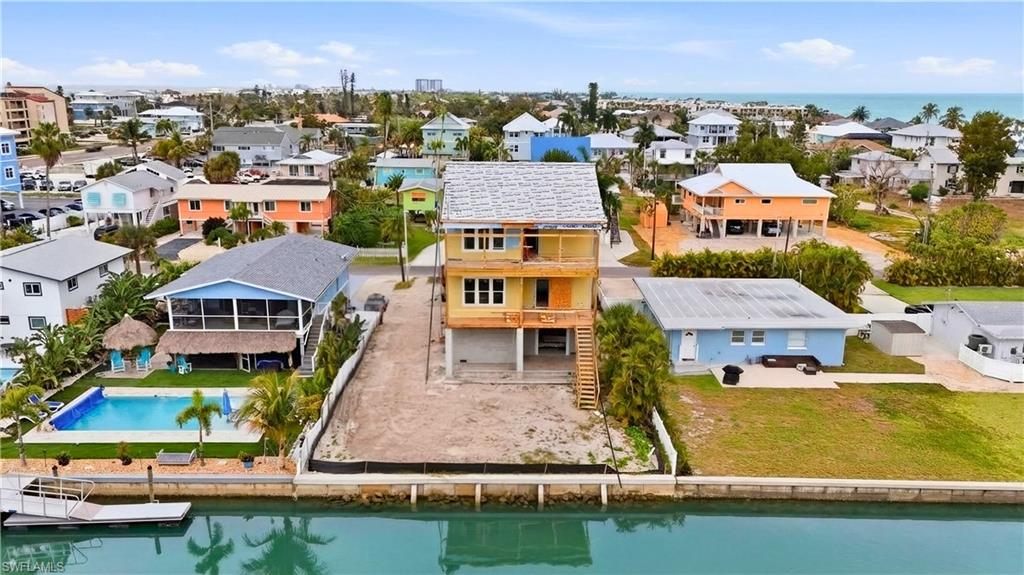 Aerial perspective of suburban area featuring a nearby body of water and a pool - Virtually Edited Image