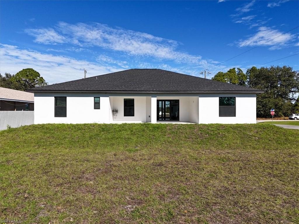 Back of property with stucco siding, a patio area, and a shingled roof