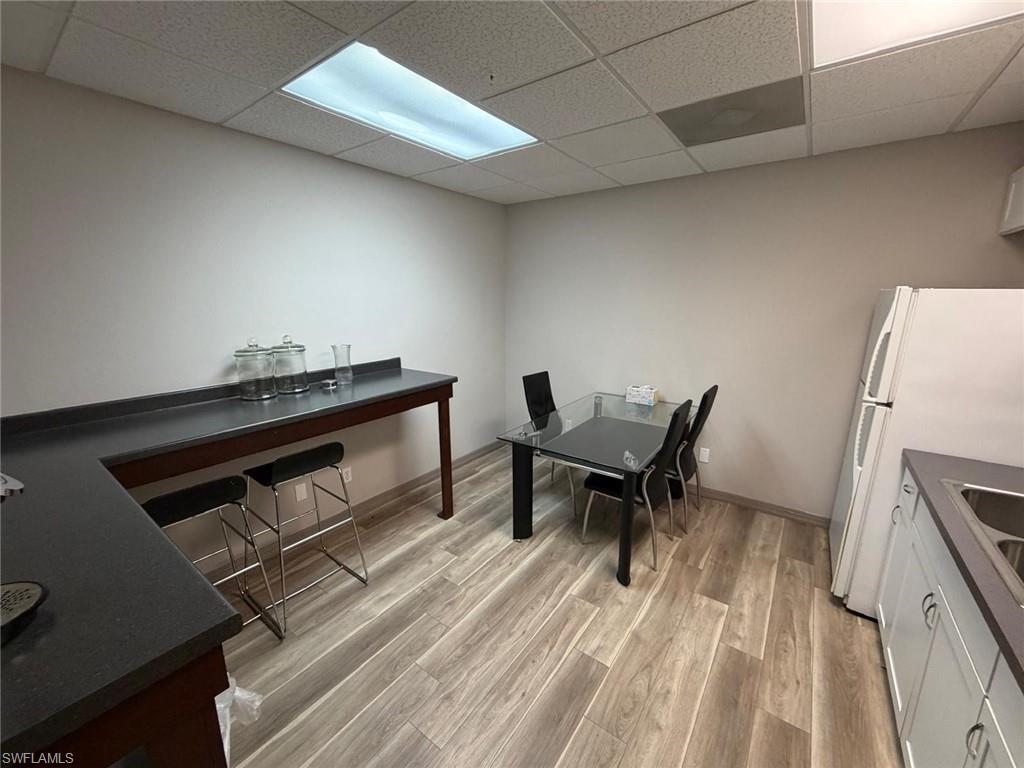 Dining area featuring light wood finished floors and a paneled ceiling