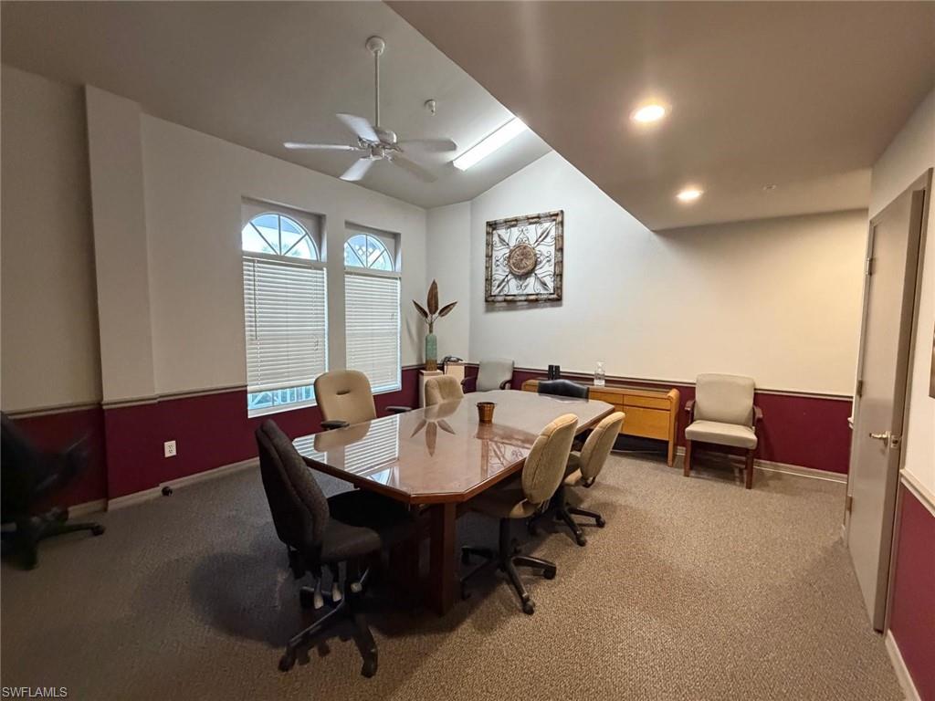Carpeted office space featuring vaulted ceiling, a ceiling fan, and recessed lighting