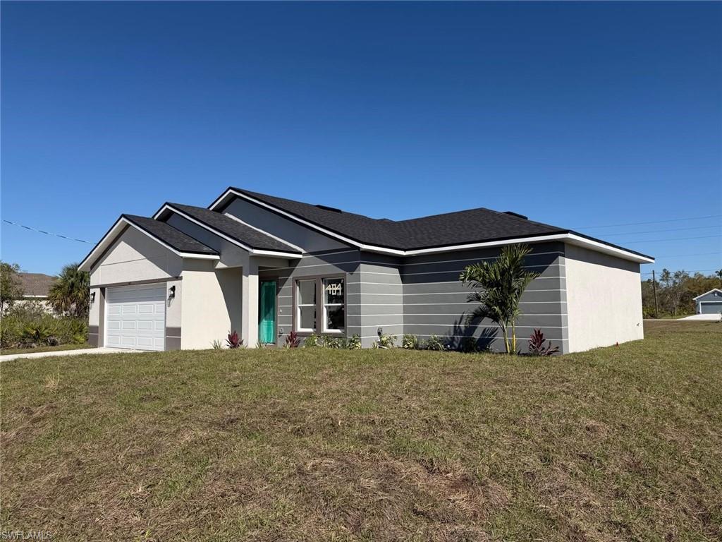 Ranch-style house featuring a front yard, an attached garage, stucco siding, roof with shingles, and concrete driveway