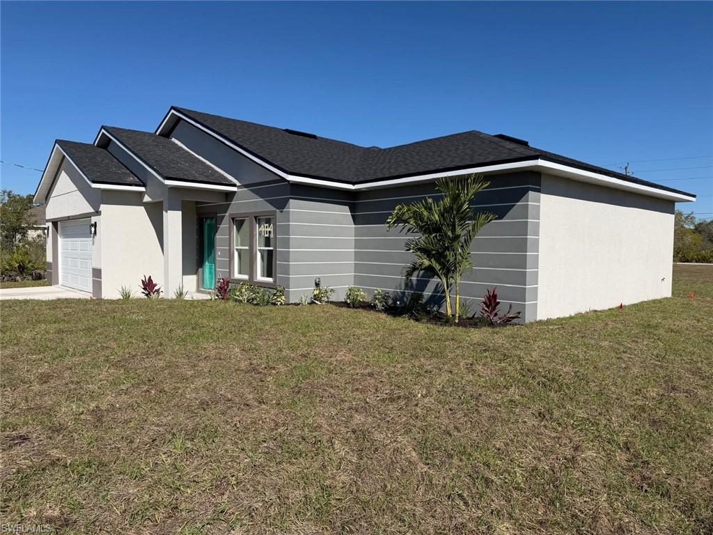 View of front of property with a front lawn, a garage, driveway, and roof with shingles
