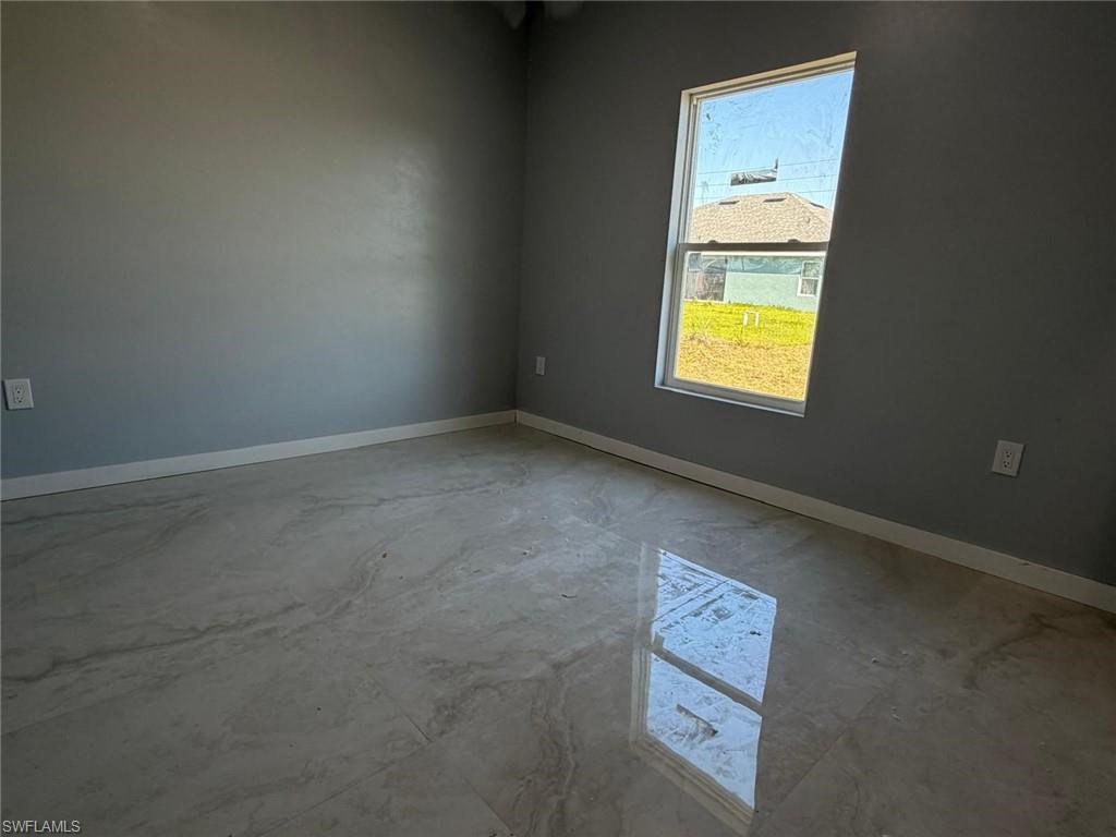 Spare room with baseboards and unfinished concrete flooring